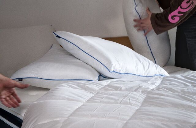 Oreillers blancs posés sur un lit garni d'une couette