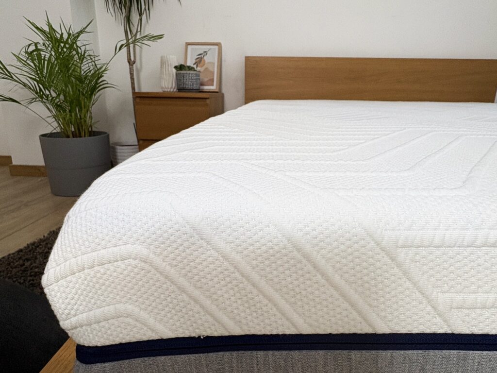 Angle du matelas Mello Hybride : coutil matelassé blanc et bordure bleu marine