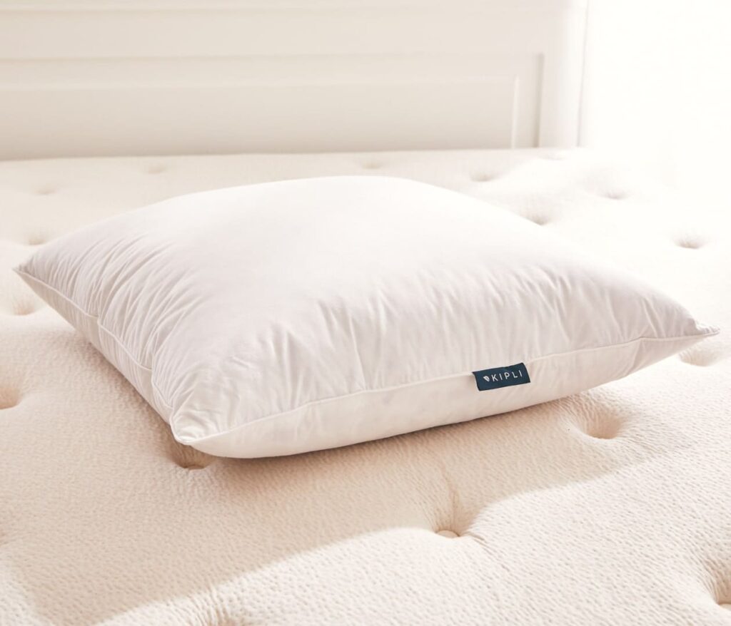 Oreiller Kipli en plumes et duvet en situation sur un lit