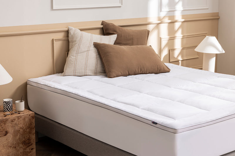 Surmatelas Mello Duo sur un lit avec coussins