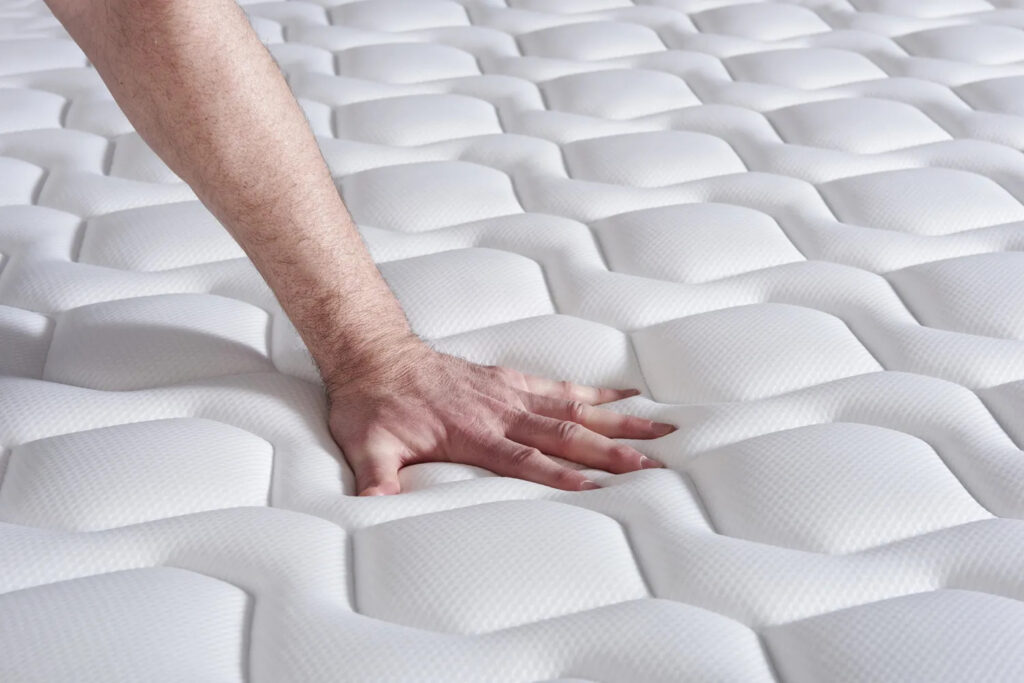 Main appuyée sur le coutil matelassé de l'Actisom Actiflex Pur