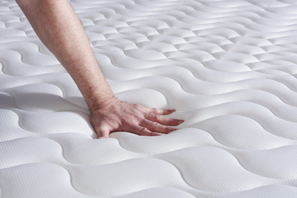 Main pressant le coutil matelassé de l'Actisom Actilatex Life