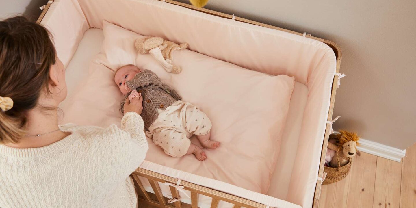 Flexa lit bébé Nova avec matelas, posé sur un parquet clair