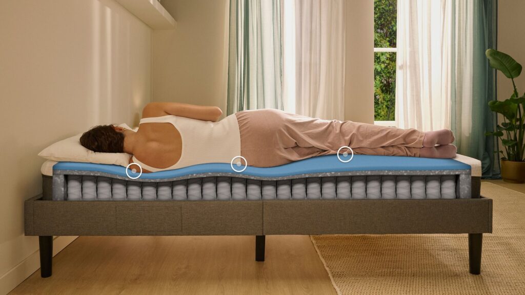 Dormeuse sur le côté sur le matelas Emma Original Lite, couches visibles en coupe
