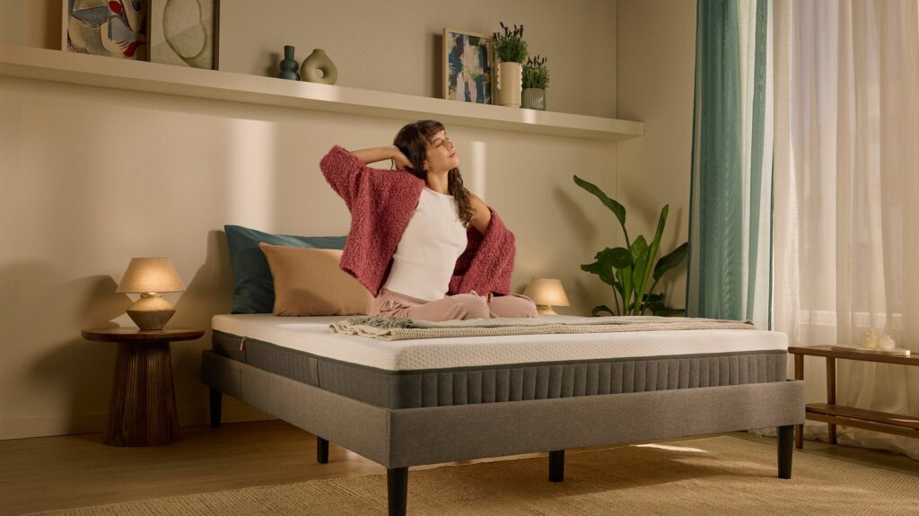 Femme assise sur le matelas Emma Original Lite dans une chambre lumineuse