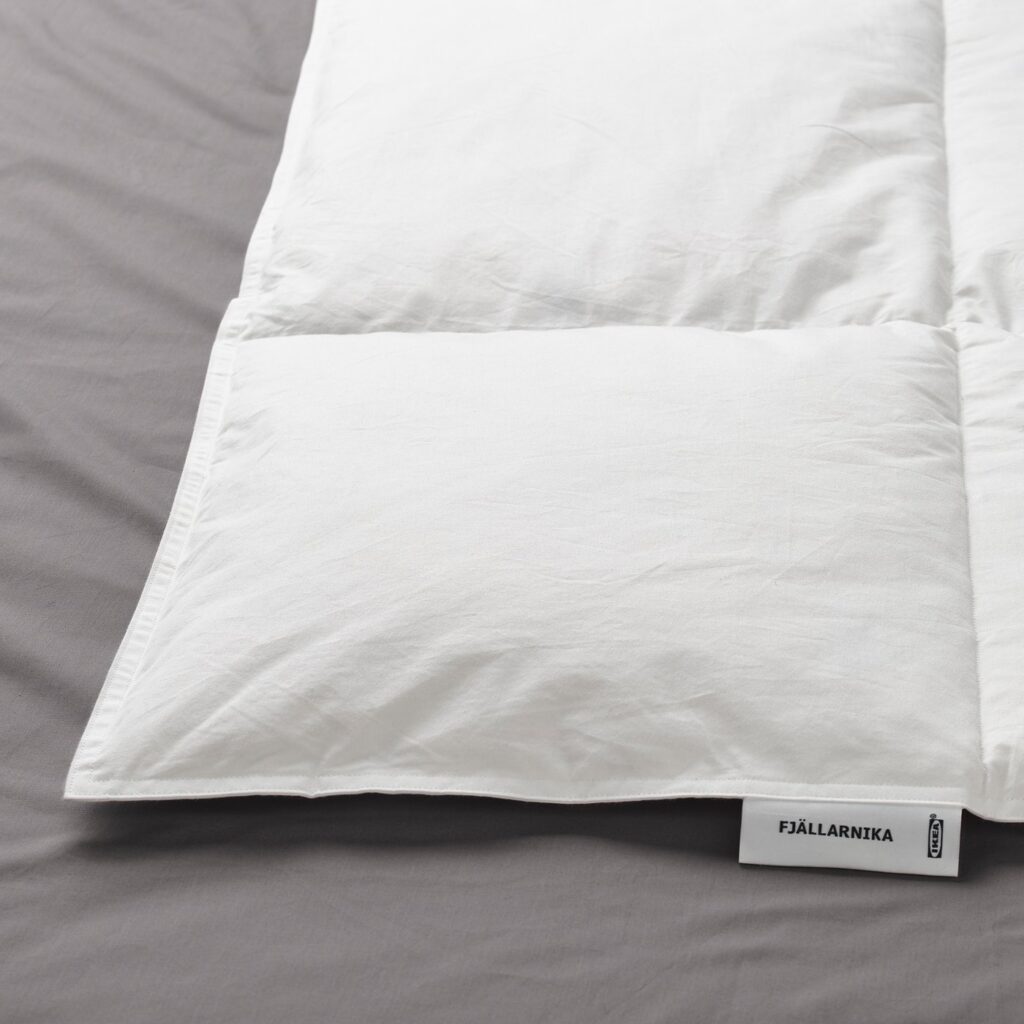 Gros plan du tissu et des surpiqûres de la couette IKEA FJÄLLARNIKA