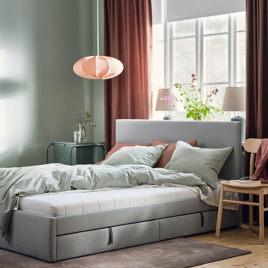 Matelas IKEA ÅFJÄLL sur un lit gris dans une chambre