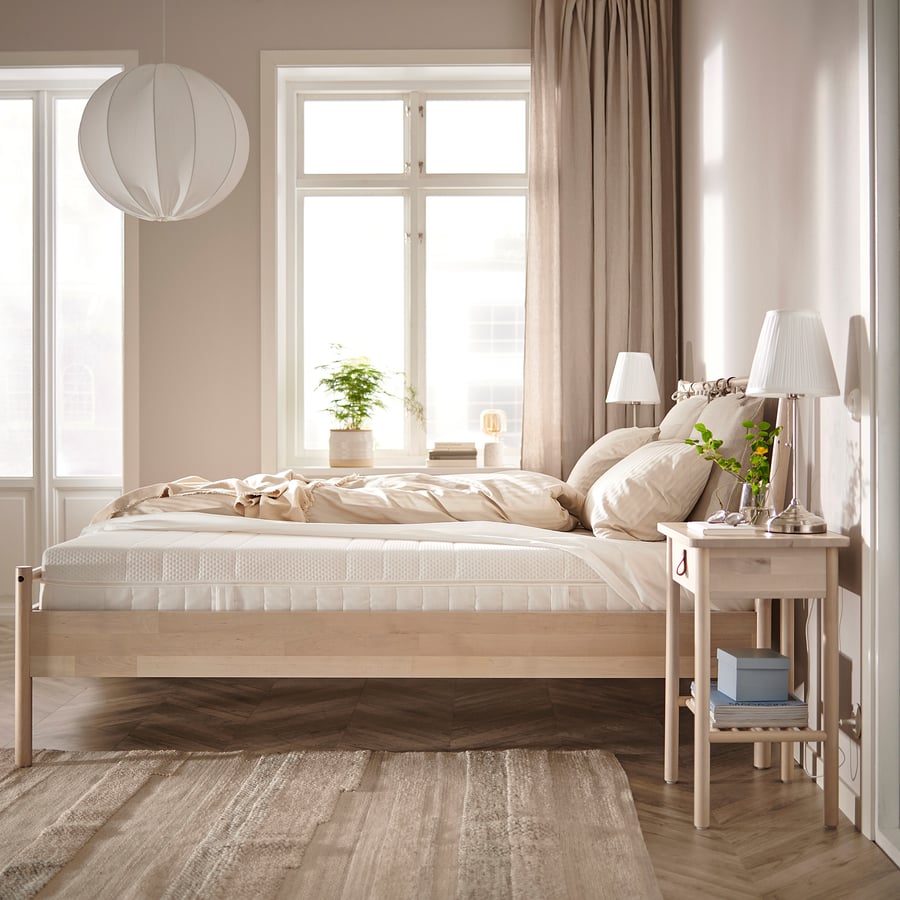 Matelas IKEA ÅKREHAMN sur un lit en bois clair dans une chambre