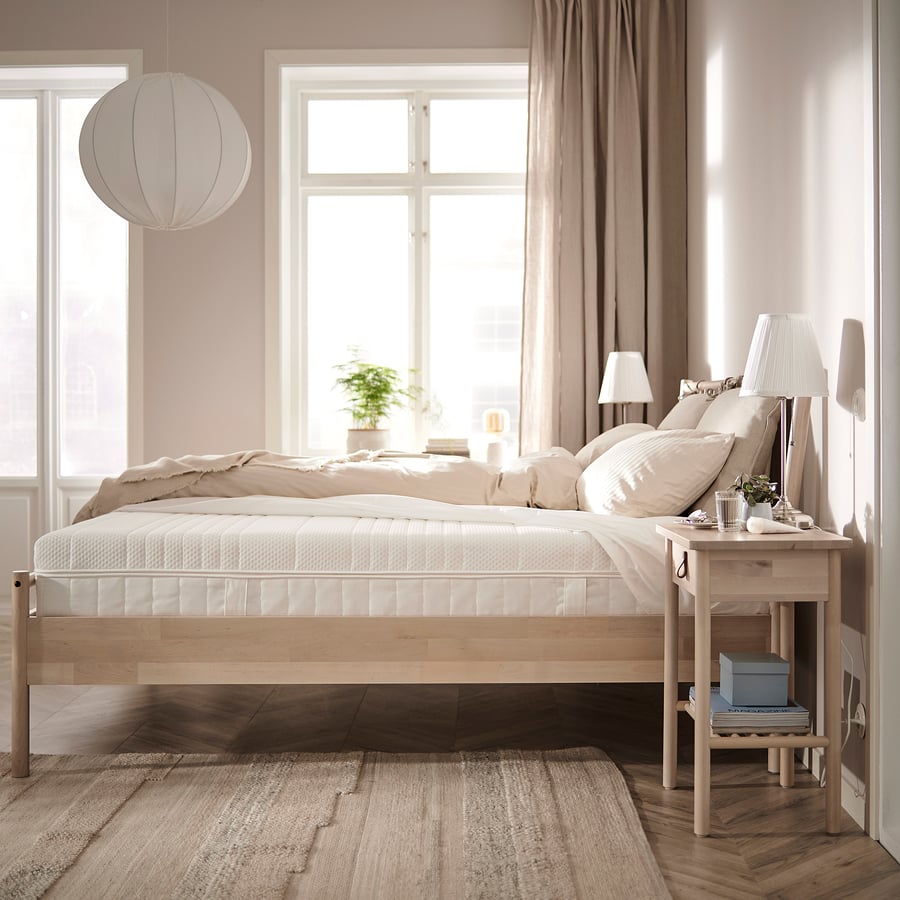 Matelas IKEA ÅNNELAND sur un lit en bois clair dans une chambre