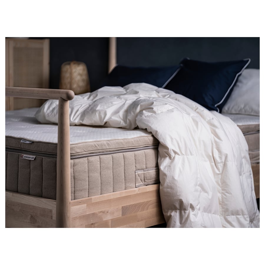 Couette IKEA FJÄLLARNIKA posée sur un lit en bois clair