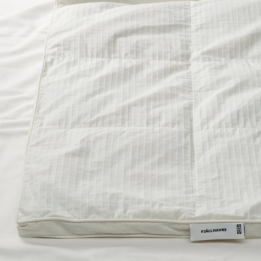 Détail de la couette IKEA FJÄLLHAVRE avec sa bande latérale et son étiquette