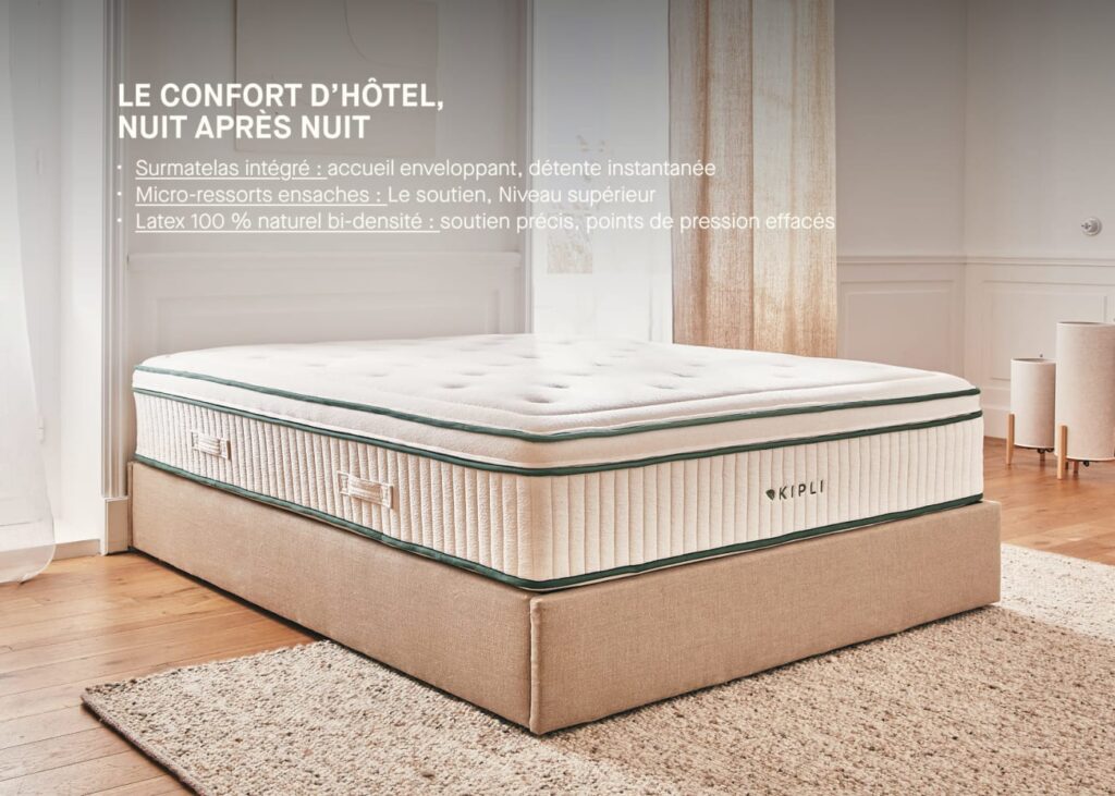 Kipli Prestige sur un lit dans une chambre lumineuse