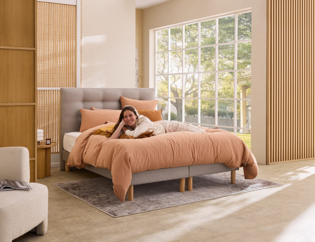 Matelas Épéda Gemme dans une chambre, avec une femme allongée dessus