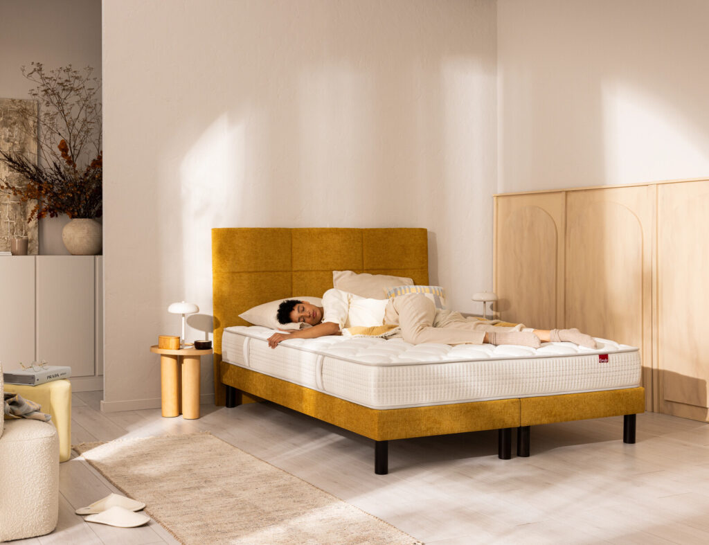 Matelas Épéda Nacrée dans une chambre, avec une personne allongée dessus