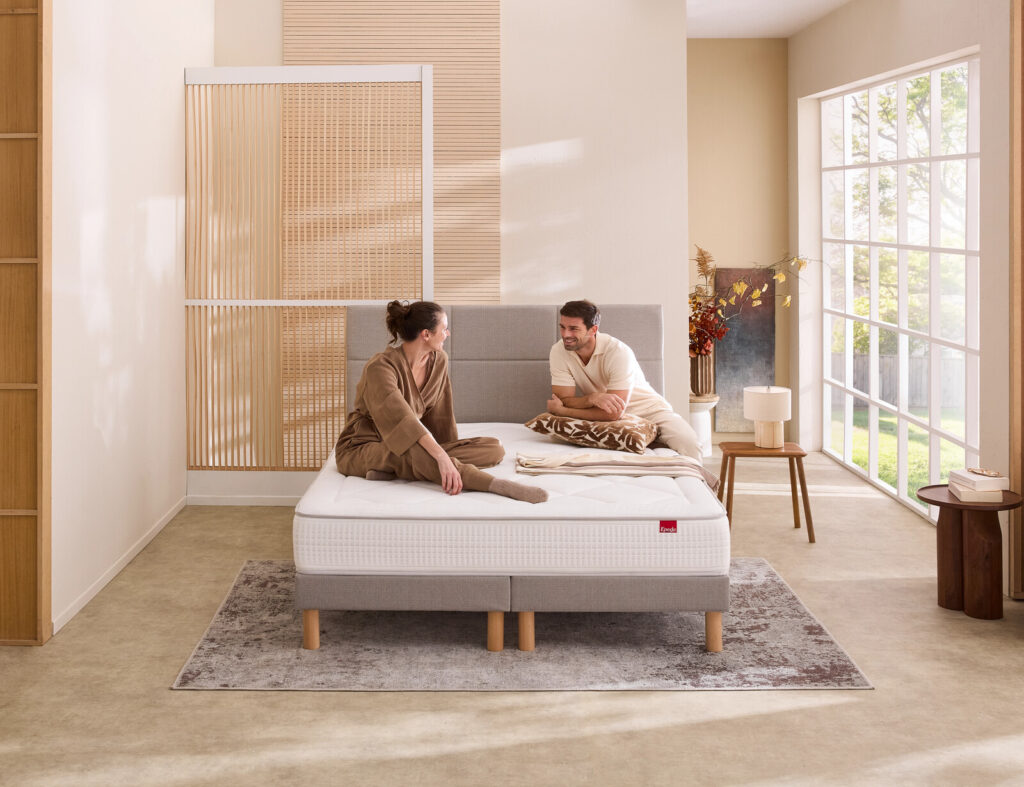 Matelas Épéda Poésie dans une chambre, avec un couple assis dessus