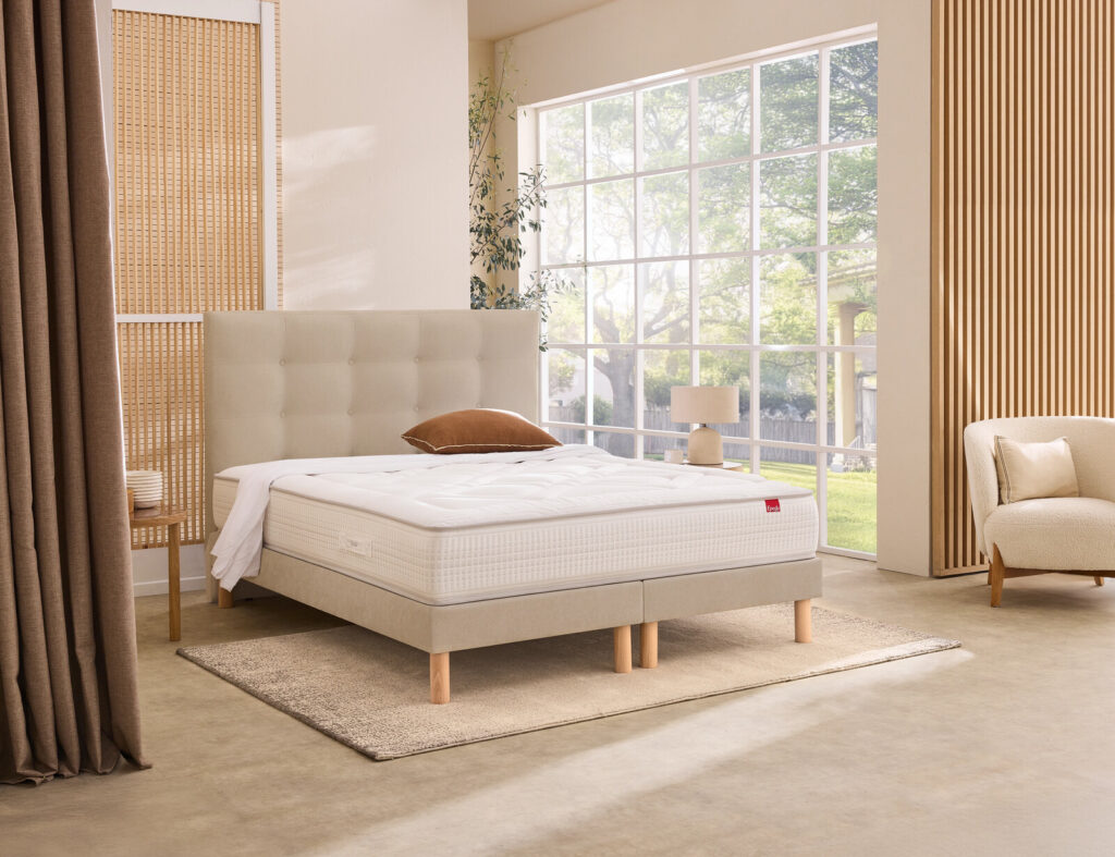 Matelas Épéda Vermillon sur un lit dans une chambre
