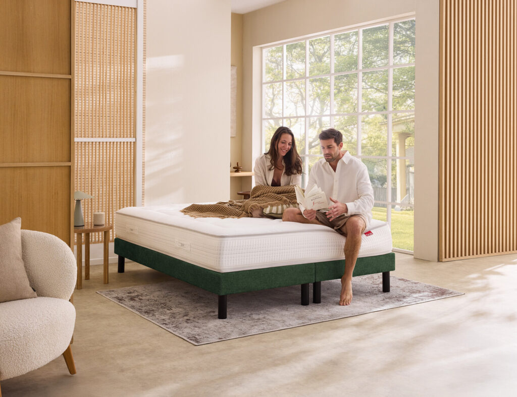 Matelas Épéda Vermillon dans une chambre, avec un couple assis dessus
