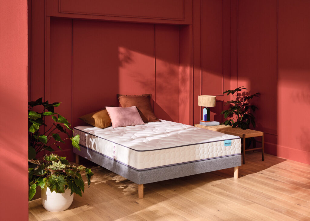 Matelas Mérinos Cosy Lit sur un lit double dans une chambre rouge brique
