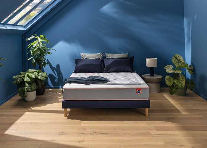 Matelas Mérinos Marinière Iconique sur un lit double dans une chambre bleue