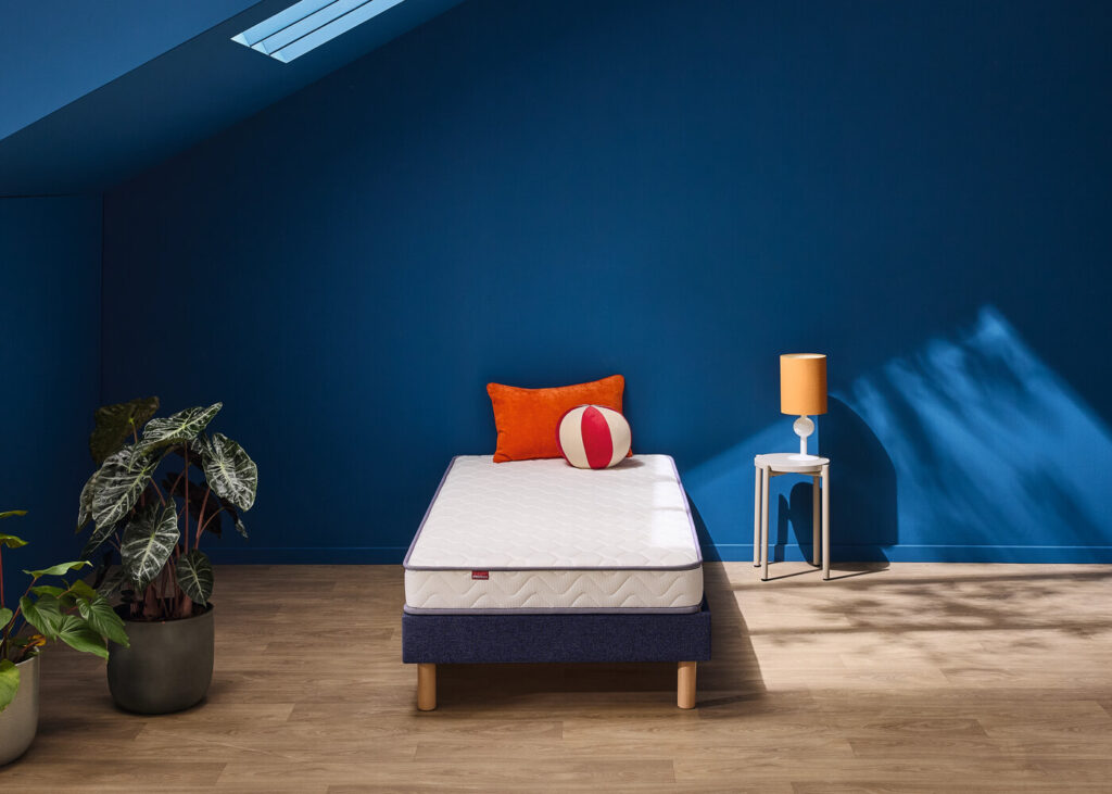 Matelas Mérinos Positive Lit sur un lit une place dans une chambre bleue