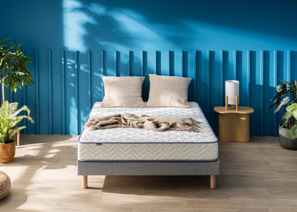 Matelas Mérinos Smiling sur un lit double dans une chambre bleue