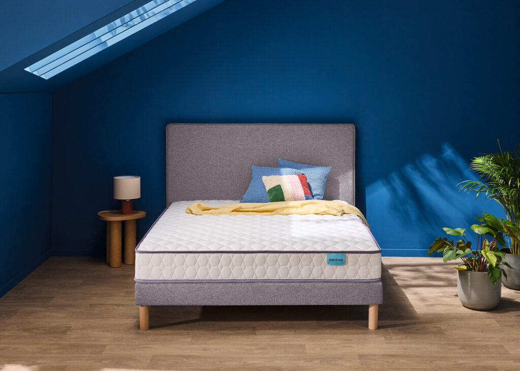 Matelas Mérinos Well Bed sur un lit double dans une chambre bleue