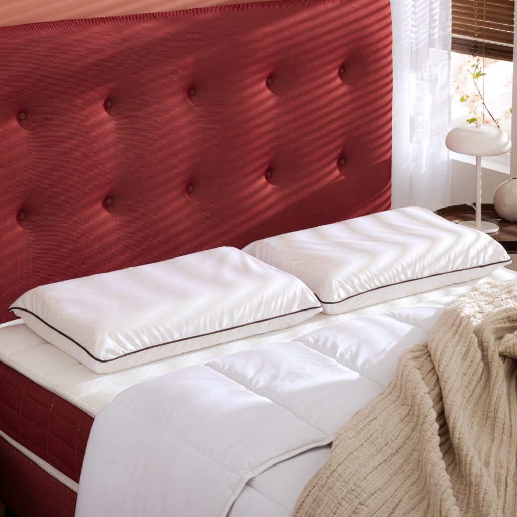 Oreillers ergonomiques Someo en latex naturel posés sur un lit