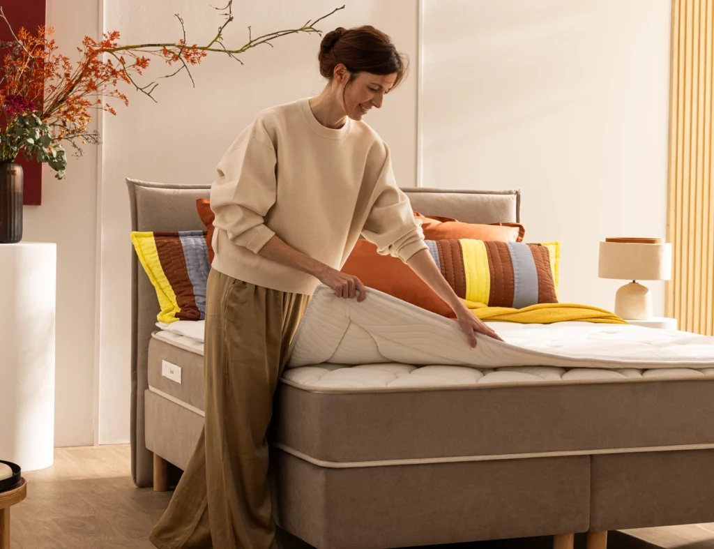 Une utilisatrice installe le surmatelas Épéda Noblesse sur son matelas