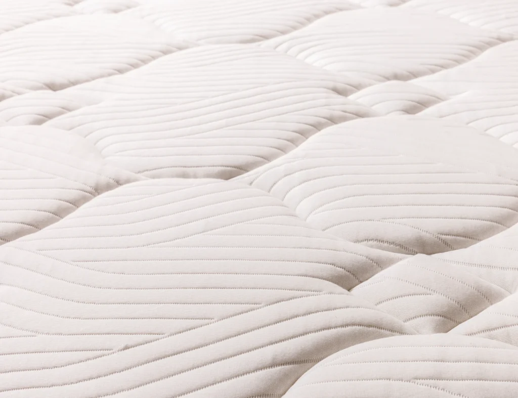 Gros plan sur le piquage matelassé du surmatelas Épéda Noblesse