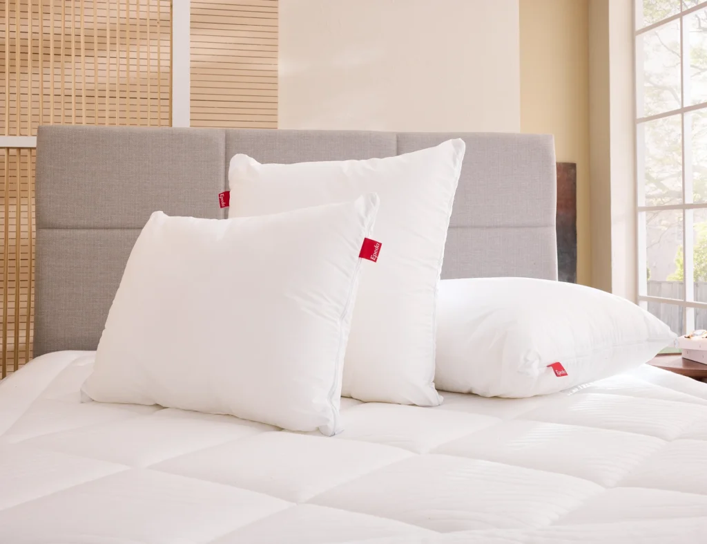 Oreillers carrés et rectangulaire Épéda Nuance posés sur un lit