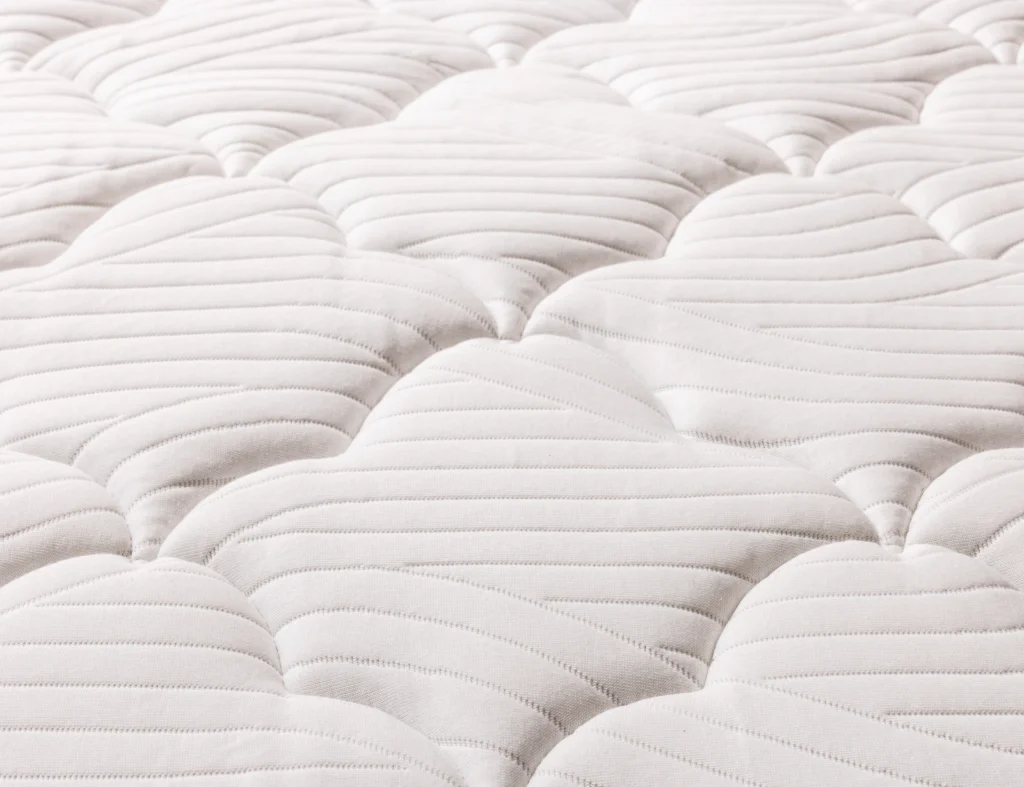 Gros plan sur le piquage matelassé du surmatelas Épéda Harmonie