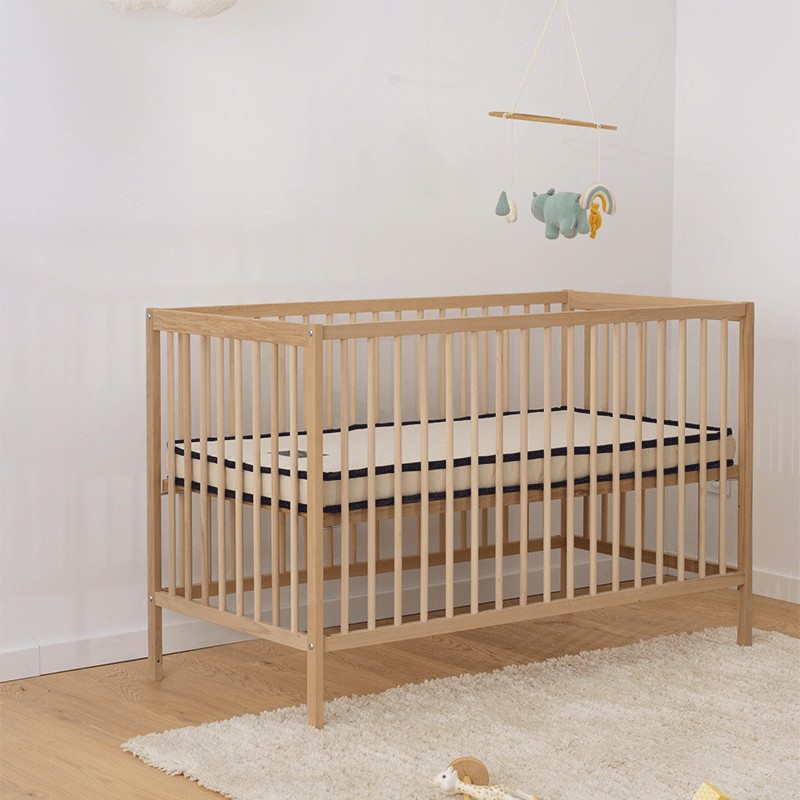Matelas bébé Le Petit Cosme dans un lit à barreaux