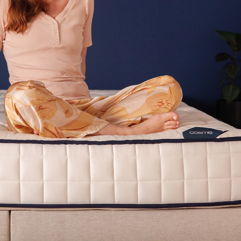 Femme assise sur le matelas Cosme Latex et Ressorts Ferme