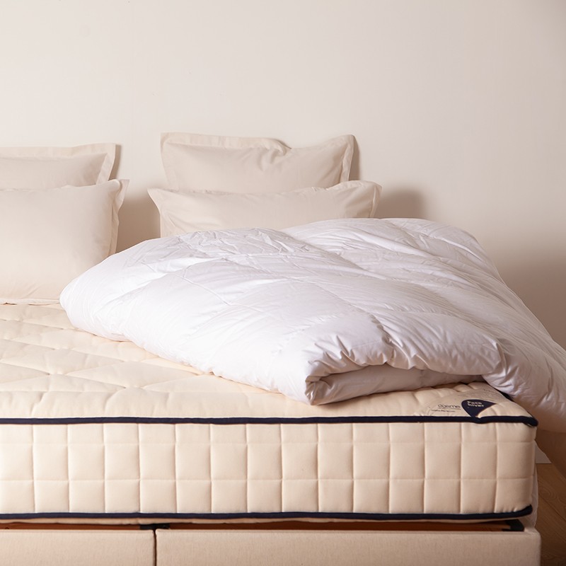 Matelas Cosme Mal de Dos avec couette dans une chambre