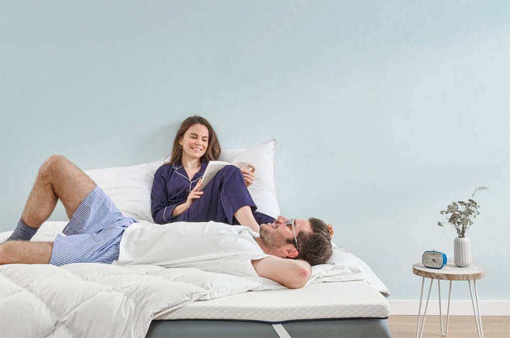 Couple lisant sur un lit equipe du surmatelas Nyte Air