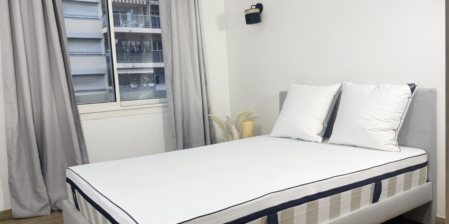 Chambre lumineuse avec un lit placé près d'une grande fenêtre