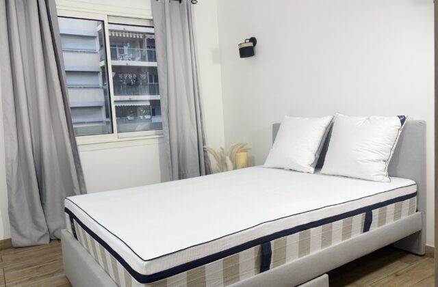 Chambre lumineuse avec un lit placé près d'une grande fenêtre