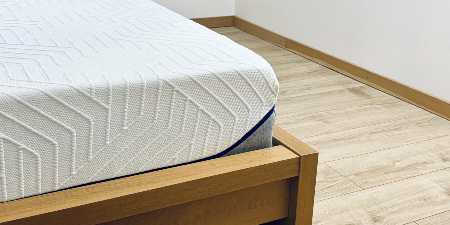 Coin d'un matelas posé sur un cadre de lit en bois