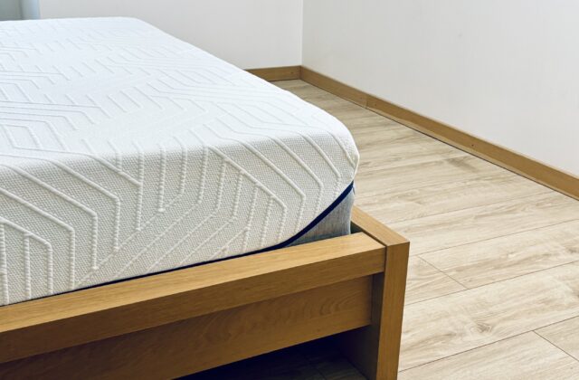Coin d'un matelas posé sur un cadre de lit en bois