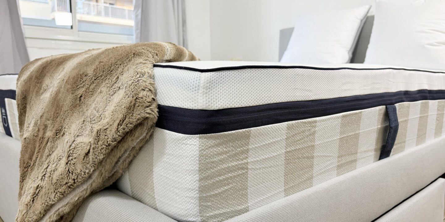 Coin de matelas avec un plaid drapé sur le bord