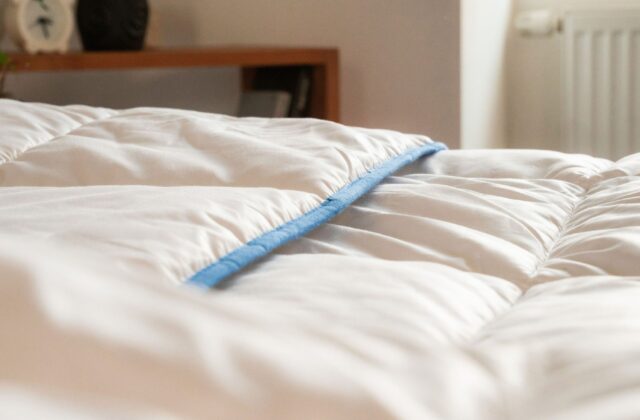 Gros plan sur une couette blanche moelleuse au passepoil bleu