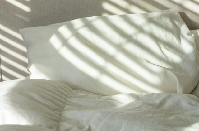 Lit avec linge blanc dans une chambre lumineuse