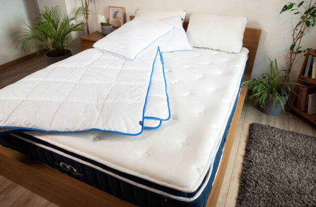 Lit double avec une couette blanche repliée sur le matelas et deux oreillers, photographié pendant notre test