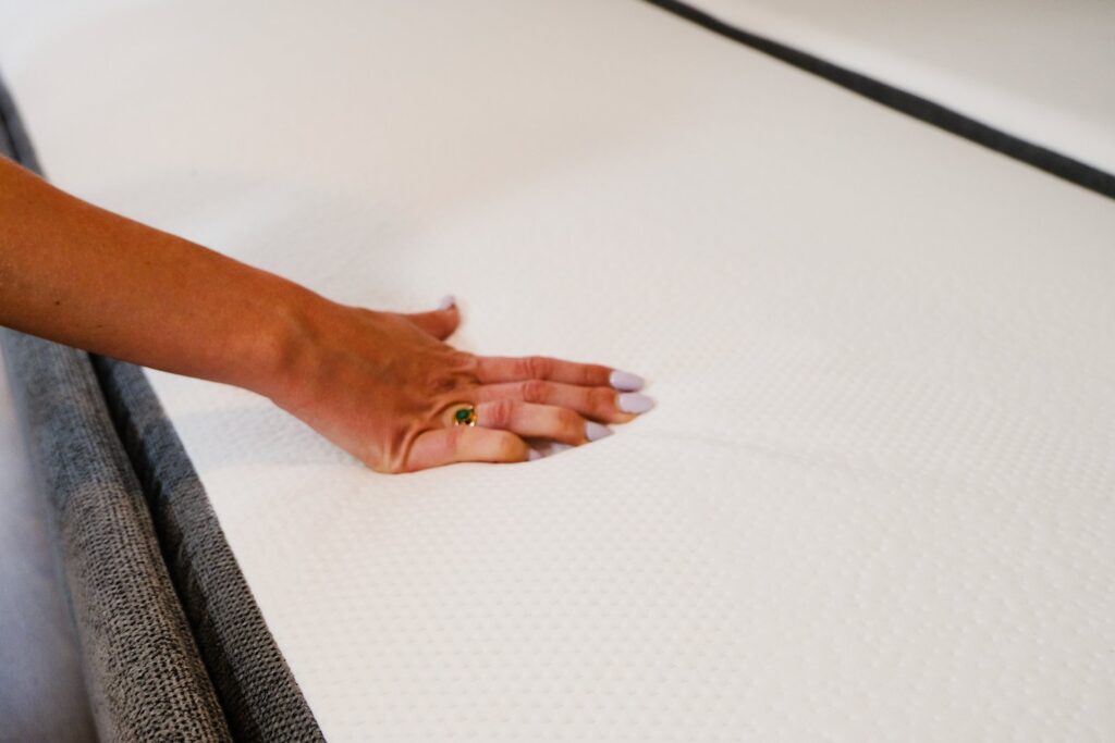 Main sur le matelas du convertible Emma Original près du bord