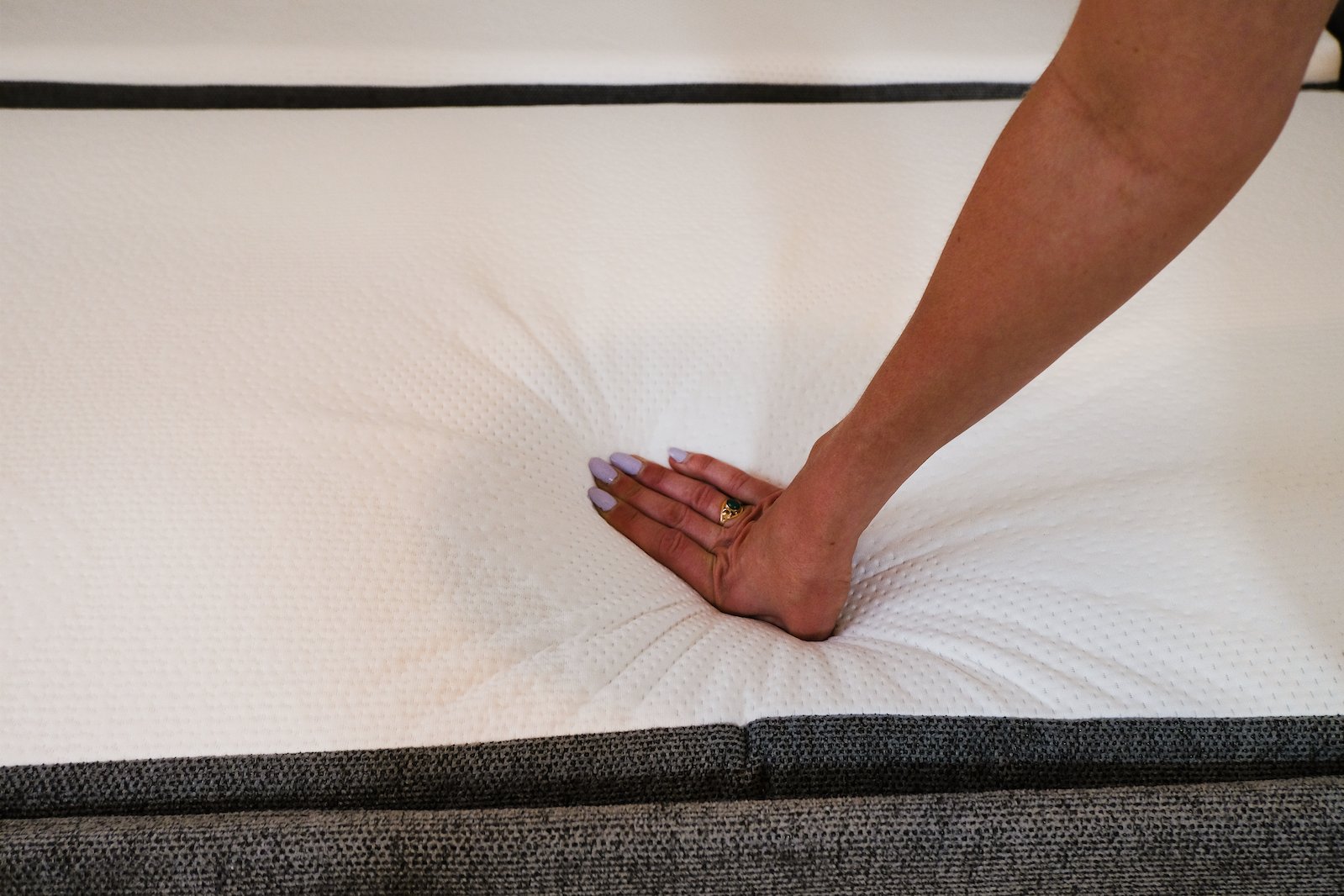 Main appuyant sur le matelas du canapé convertible Emma Original