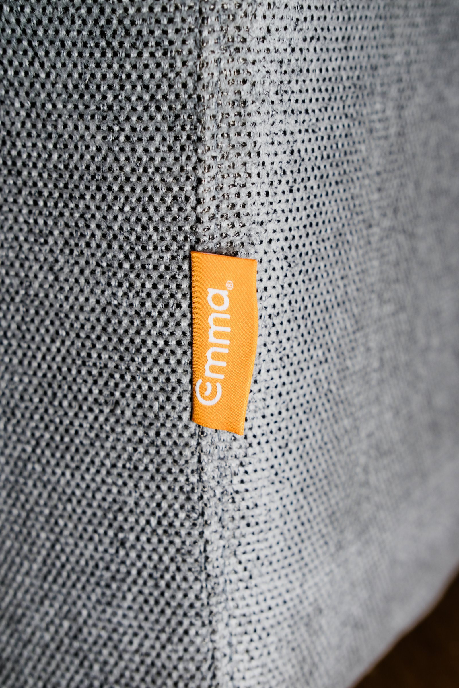 Gros plan sur le tissu et l'étiquette Emma du canapé convertible Original
