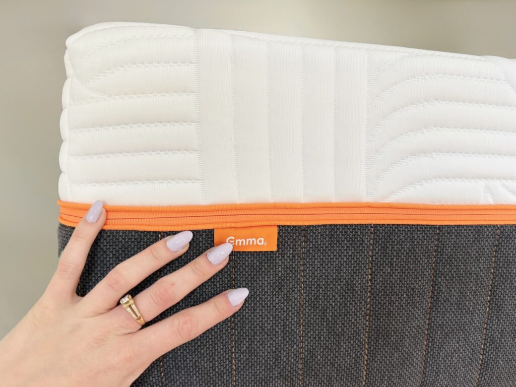 Main posée sur le flanc tissé du matelas Emma Performance