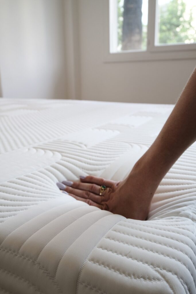 Main appuyant sur la surface du matelas Emma Performance