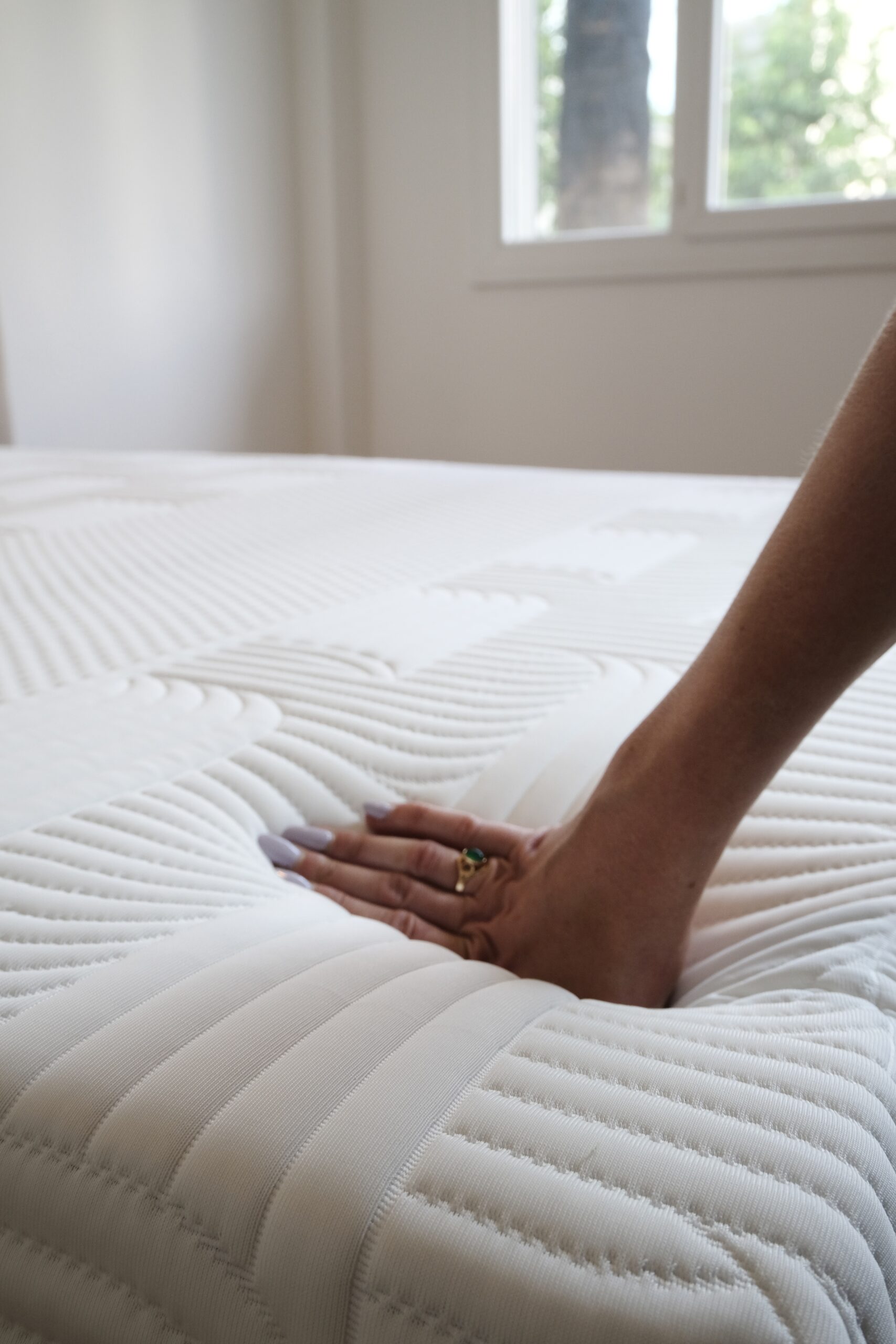 Main appuyant sur la surface du matelas Emma Performance