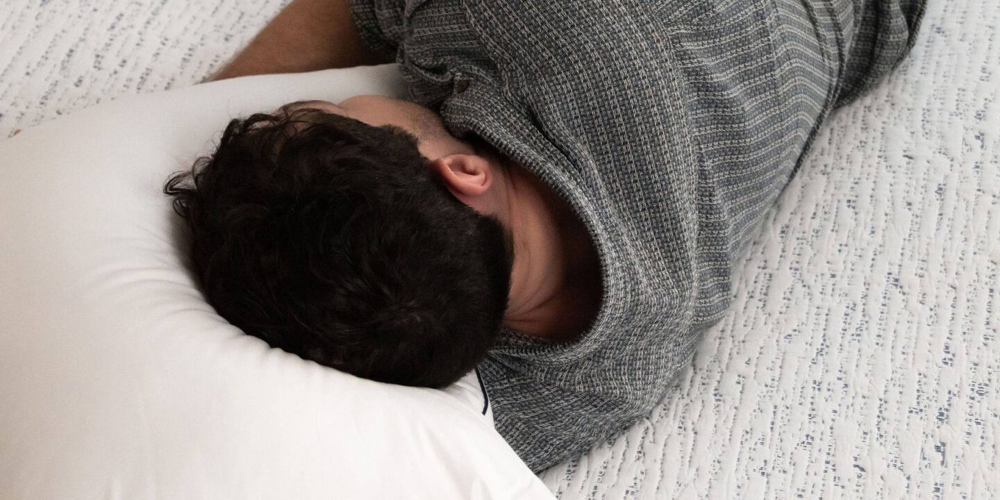Homme allongé sur le ventre, le visage dans l'oreiller